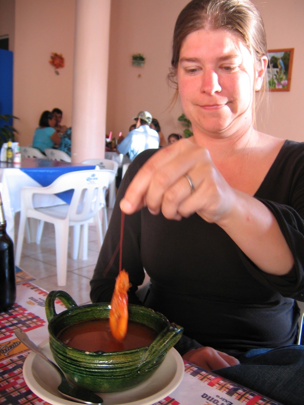 woman pulls prawn out of soup by the antennae